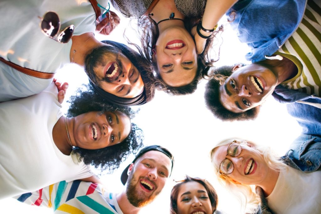 TheREDWords.website/BLOG page. A photo of a group of young people in a circle and smiling down at the camera.